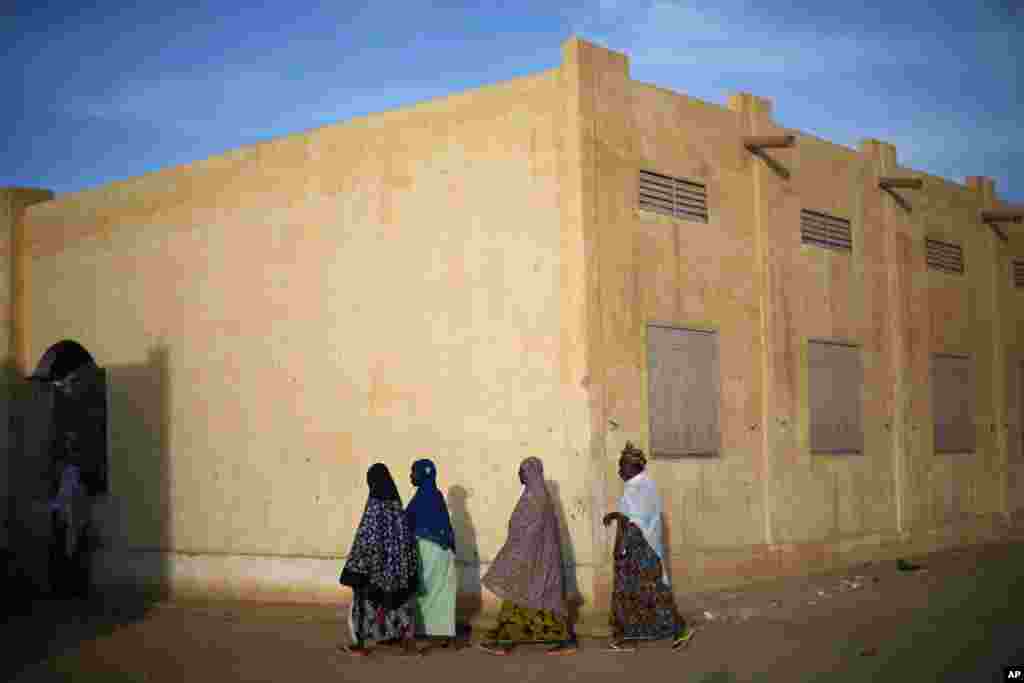 Women walk around a polling station waiting for it to close in Mali's parliamentary elections in Gao, Nov. 24, 2013.