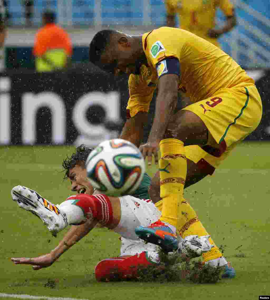 Mexico's Hector Moreno (on the ground) fights for the ball with Cameroon's Samuel Eto'o during their 2014 World Cup Group A soccer match at the Dunas arena, in Natal June 13, 2014. 