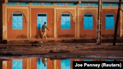 Un honne passe dans une école fermée, à Niamey, le 15 septembre 2013.