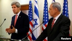 Israeli Prime Minister Benjamin Netanyahu (R) listens as U.S. Secretary of State John Kerry speaks during a news conference following a meeting at Netanyahu's office in Jerusalem, Dec. 5, 2013.