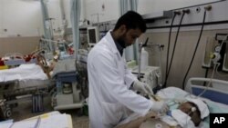 A Libyan doctor treats a wounded man who was injured last week during the demonstration against Libyan Leader Moammar Gadhafi, in Benghazi, Libya, February 24, 2011