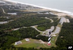 The Cape Hatteras lighthouse sits way off the beach in Buxton, NC., Saturday, Sept. 15, 2018. (AP Photo/Steve Helber)