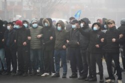 Demonstrators stand in front of a police line during a protest in Almaty, Kazakhstan, Jan. 5, 2022.