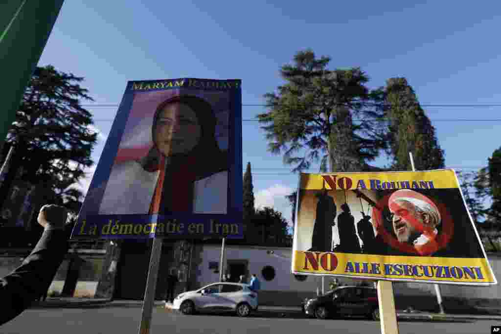 Masu zanga zanga dauke da tutar Maryam Rajavi madugun &#39;yan adawar kasar Iran, National Resistance Council, da kwalaye da aka yi rubutu kansu da harshen Faransanci suna cewa &quot;Dimokradiya a Iran&quot;. Ta hannun hagu kuma akwai hoton shugaban Iran Hassan, Janairu 02, 2018
