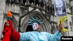 Pristalica Juliana Assangea ispred suda u Londonu sa transparentnom na kojem se traži njegovo oslobađanje, 21. februar 2024. (REUTERS/Toby Melville)
