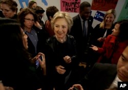 FILE - Democratic presidential candidate Hillary Clinton, center, greets supporters as she visits her campaign field office in Oakland, Calif., May 6, 2016.