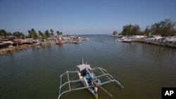 FILE - In this May 7, 2013 photo, a fishing boat returns to their village in the coastal town of Masinloc, Zambales province, northwestern Philippines.