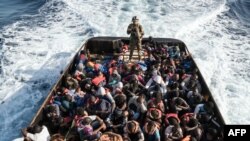 FILE - A Libyan coast guardsman stands on a boat during the rescue of 147 migrants trying to reach Europe off the coastal town of Zawiyah, 45 kilometers west of Tripoli, June 27, 2017.