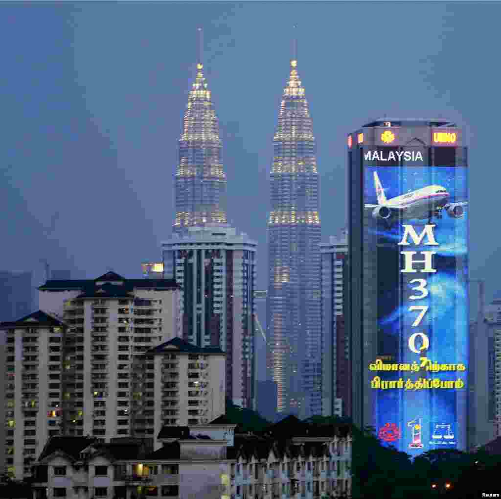 Gambar yang menunjukkan dukungan pada Malaysia Airlines penerbangan MH370 terlihat di gedung partai berkuasa Malaysia, United Malays National Organisation (UMNO), di Kuala Lumpur (19/3).