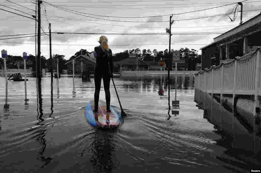 Zoe Jurusik, 20, paddleboards down a flooded city street in the aftermath of Hurricane Sandy in Bethany Beach, Delaware, October 30, 2012. 