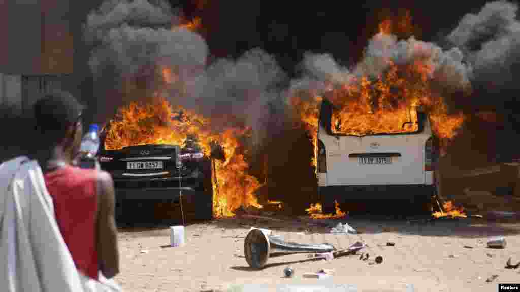 Seorang pria mengamati mobil yang terbakar di sebuah hotel, tempat tinggal para anggota parlemen Burkina Faso di&nbsp;Ouagadougou, ibukota Burkina Faso (30/10). 