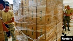 U.S. airmen from the 8th Expeditionary Air Mobility Squadron prepare boxes of halal meals for a humanitarian drop over Iraq in August 2014. A 2016 budget increase in foreign aid includes more support for humanitarian assistance.