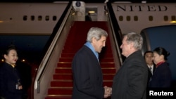 Američki državni sekretar Džon Keri pozdravlja se sa ambasadorom SAD u Kini, Maksom Bokusom po dolasku u Peking, 26. januara 2016.