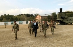 U.S. Defense Secretary Mark Esper, center, walks Gen. Scott Miller, right, chief of the U.S.-led coalition in Afghanistan, at the U.S. military headquarters in Kabul, Afghanistan, Sunday, Oct. 20, 2019.