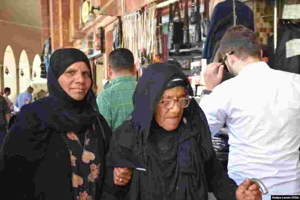 Wasu mata suna tafiya a cikin kasuwar garin Irbil