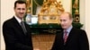 FILE - In this Tuesday, Dec. 19, 2006 file photo Vladimir Putin, then Russian President, right, and his Syrian counterpart Bashar Assad smile as they shake hands in Moscow's Kremlin 