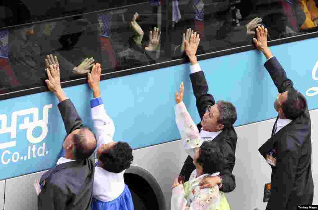 South Koreans touch bus windows in their attempt to feel the hands of their North Korean relatives as they bid farewell after the Separated Family Reunion Meeting at Diamond Mountain resort in North Korea, Oct. 26, 2015.