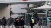 FILE - Policemen stand guard in front of the court building in Beijing.