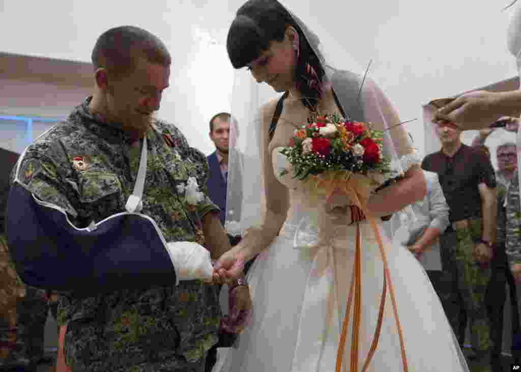 Donetsk People's Republic platoon commander Arsen Pavlov, also known as Motorola, and Elena Kolenkina exchange rings during their wedding ceremony in the city of Donetsk, eastern Ukraine.