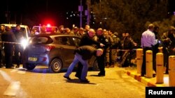 Israeli security forces and emergency personnel work at the scene of a shooting attack, near the Israeli settlement of Ofra, in the occupied West Bank, Dec. 9, 2018. 