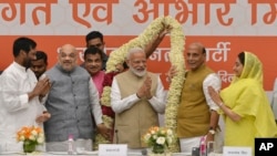 Bharatiya Janata Party (BJP) President Amit Shah (2nd-L) and cabinet members present a garland to Indian Prime Minister Narendra Modi at a function to thank cabinet members for their service in the term that is about to end, in New Delhi, India, May 21, 2019.