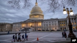 FILE - People walk by the U.S. Capitol in Washington, Jan. 21, 2018.