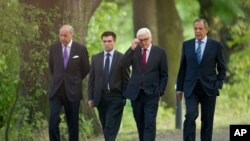 Foreign Ministers of France Laurent Fabius, Ukraine Pavlo Klimkin, Germany Frank-Walter Steinmeier and Russia Sergey Lavrov, from left, go for a walk before a meeting at the Guesthouse of Foreign Ministry Villa Borsig in Berlin, Sunday, Aug. 17, 2014.