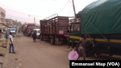 Des camions stationnés au lieu dit Marché 8ème attendent les chargements de filets d’oignons pour le Gabon, à Yaoundé, Cameroun, 20 février 2017. (VOA/Emmanuel Ntap).