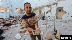 Palestinci pregledaju mjesto izraelskog napada na skladište pomoći u izbjegličkom kampu Al-Nuseirat