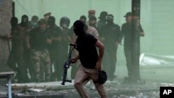 Iraqi security forces try to disperse anti-government protesters during ongoing protests in downtown Baghdad, Iraq, Sunday, Nov. 10, 2019.