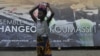 A girl stands next to a campaign poster of Cisse Ibrahima "Bacongo," a candidate for the municipal elections, on April 19, 2013 in Abidjan, two days ahead of the vote.