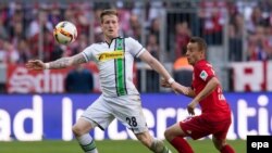 L’attaquant Rafinha de Munich, à droite, et André Hahn de Gladbach se battent pour récupérer un ballon lors du match de football de la Bundesliga entre le Bayern Munich et le Borussia Moenchengladbach, Munich, le 30 avril 2016.
