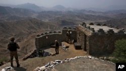 FILE - In this Aug. 3, 2021 file photo, Pakistan Army troops observe the area from hilltop post on the Pakistan-Afghanistan border in Khyber district, Pakistan. Pakistani authorities, Nov. 8, 2021, announced a month-long cease-fire with the TTP, a key mil