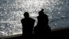 FILE - A couple is silhouetted at the harbor of Livorno, central Italy, Feb. 14, 2017.