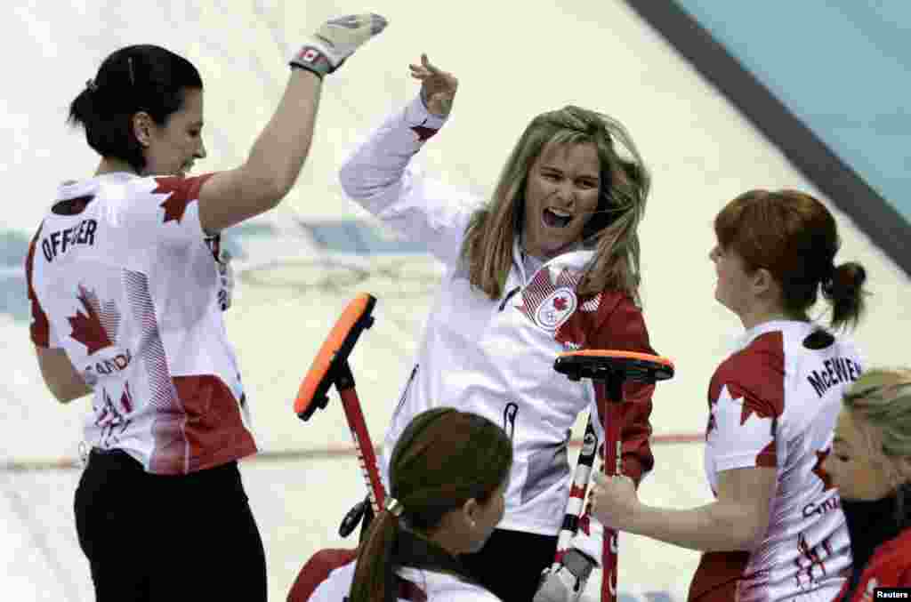 Canada's skip Jennifer Jones (center) celebrates with teammates Jill Officer (left) and lead Dawn McEwen after winning the women's curling semifinal game against Britain, Ice Cube Curling Center, Sochi Feb. 19, 2014.