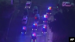 In this image made from aerial video, police vehicles block an intersection in the vicinity of a shooting in Thousand Oaks, California, early Nov. 8, 2018. Authorities say there were multiple injuries, including one officer.