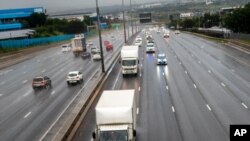 South African law enforcement vehicles provide security for two refrigeration trucks transporting the AstraZenica vaccine that arrived earlier from India, near Johannesburg, Feb. 1, 2021.