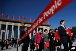 A soldier in usher uniform stands guard as delegates leave the Great Hall of the People after the closing session of China's National People's Congress (NPC) in Beijing, March 15, 2019.