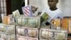 Des liasses de dollars libériens sur la table d’un cambiste à Monrovia, Libéria, 3 octobre 2005.