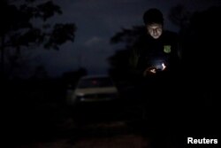An agent of the Brazilian Institute for the Environment and Renewable Natural Resources, or Ibama, looks at a GPS device during an operation to combat illegal mining and logging, in the municipality of Novo Progresso, Para State, northern Brazil, Nov. 10, 2016.