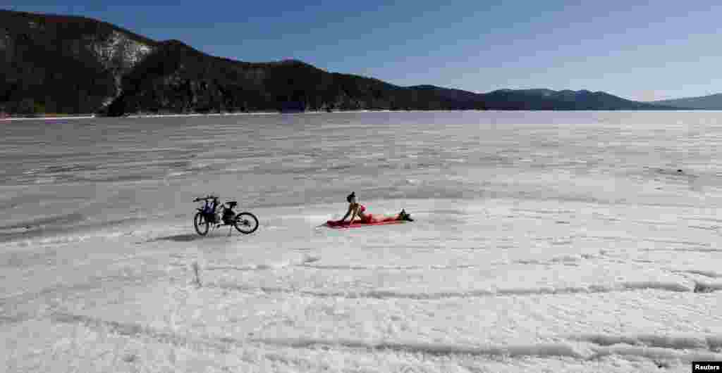 A woman enjoys the sun on the bank of the Yenisei River, with the air temperature at about 13&ordm; C (55.4&ordm; F), in the Taiga district outside Russia&#39;s Siberian city of Krasnoyarsk, April 6, 2015.