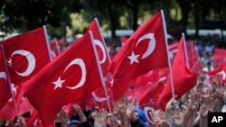 Para pengunjuk rasa pro-pemerintah melambaikan bendera Turki seraya berunjuk rasa terhadap usaha kudeta (19/6). Istanbul, Turki. (foto: AP Photo/Lefteris Pitarakis)