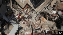 Muškarac stoji na ruševinama zgrade pogođene izraelskim zračnim napadom u južnom selu Akbieh, Liban, utorak, 24. septembra 2024. (AP Photo/Mohammed Zaatari)