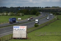 FILE - A sign reading "Boris Stop Huawei" is seen next to the M40 motorway, Tetsworth, Britain, May 1, 2020, in a reference to British Prime Minister Boris Johnson.