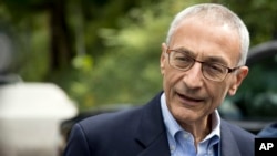 FILE - Hillary Clinton campaign chairman John Podesta speaks to members of the media outside Clinton's home in Washington, Oct. 5, 2016.