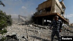FILE - A Syrian firefighter is seen inside the destroyed Scientific Research Center in Damascus, Syria, April 14, 2018.