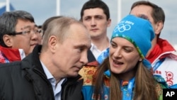 Le président russe Vladimir Poutine, avant les J.O de Sochi 2014 (Russie), avec Yelena Isinbayeva, la double championne olympique de saut à la perche, privée de Rio 2016 dans le cadre de la suspension de la Fédération russe d'athlétisme. 