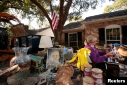 Ginger Benfield works to save family photos in the aftermath of tropical storm Harvey in west Houston, Texas, U.S. September 11, 2017.