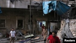 Petugas medis memeriksa kerusakan di luar rumah sakit yang terkena serangan udara di kawasan yang dikuasai pemberontak di al-Maadi, Aleppo, Suriah, 28 September 2016. 