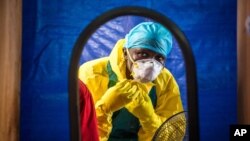 FILE -A healthcare worker dons protective gear before entering an Ebola treatment center in the west of Freetown, Sierra Leone, Oct. 16, 2014.